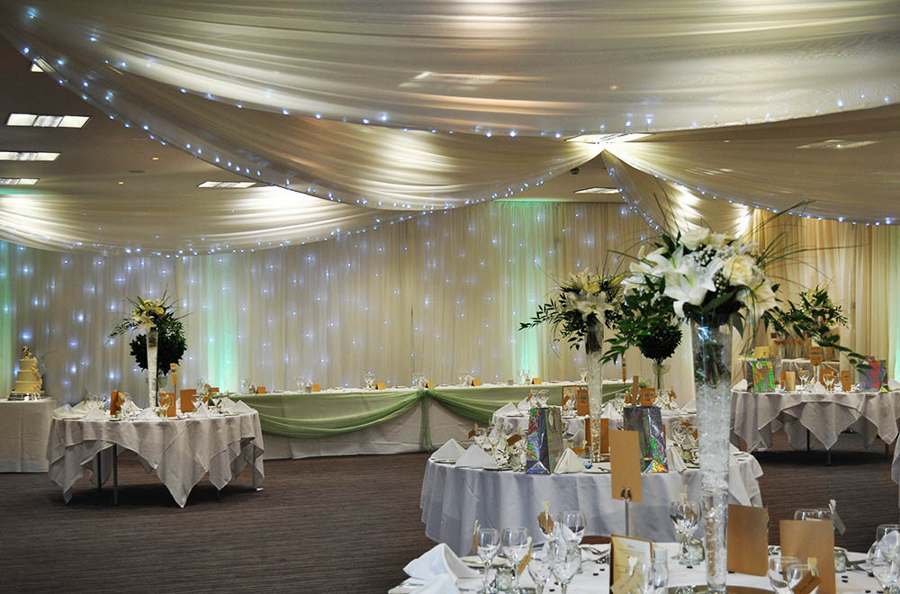 Starlit wedding drapes with Ceiling and wall drapery with integrated fairy lights at De Vere Cotswold Water Park Hotel and spa
