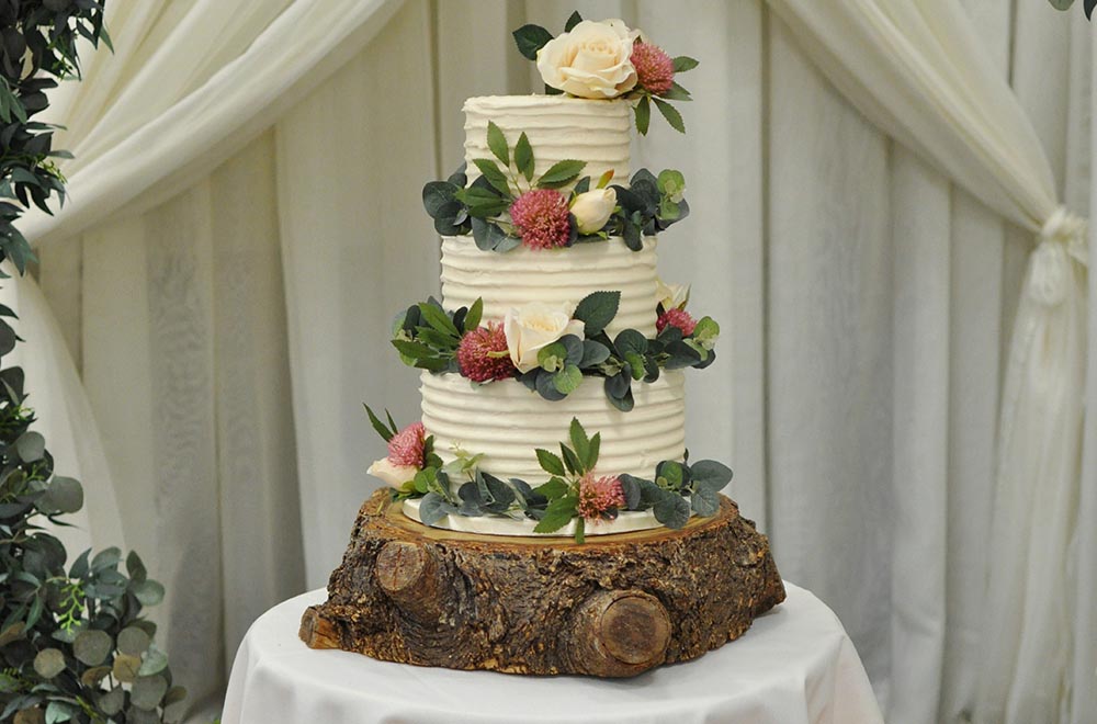 Wooden rustic Wedding cake log stand with wedding drapes in Swindon