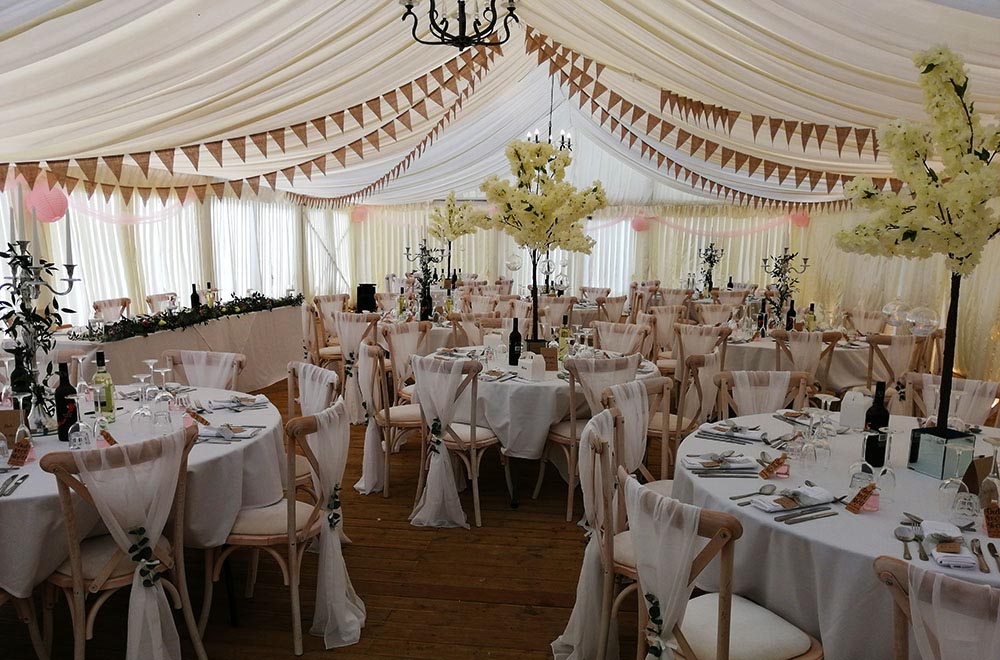 white chiffon chair decoration with blossom tree centrepieces at Stanton Manor, Chippenham