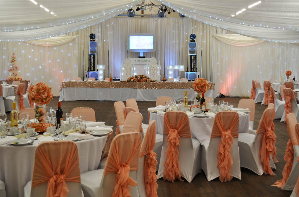 Blush pink and Peach ruggle chair cover hoods and wall and ceiling drapes at Swindon Supermarine wedding venue