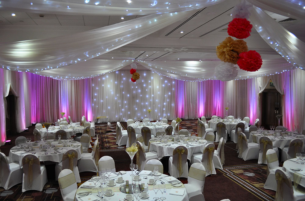 Wall and ceiling wedding drapery at the Marriott Hotel Swindon with pink uplighting on the drapes