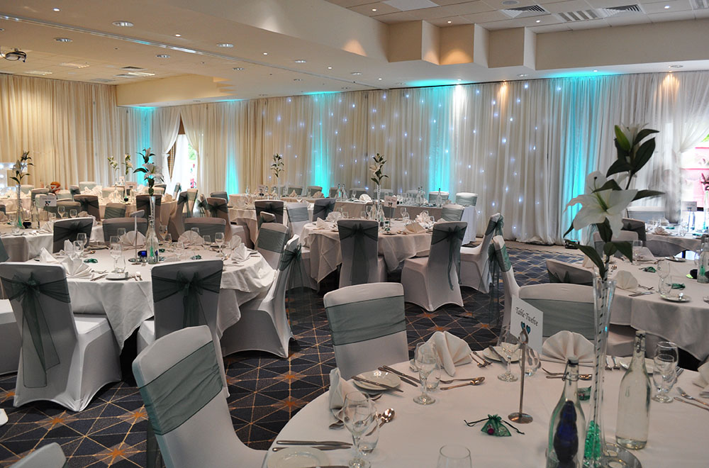 Wedding drapes at Alexandra House Conference Centre Wroughton, Swindon. Chair covers and sashes and blue uplighting.