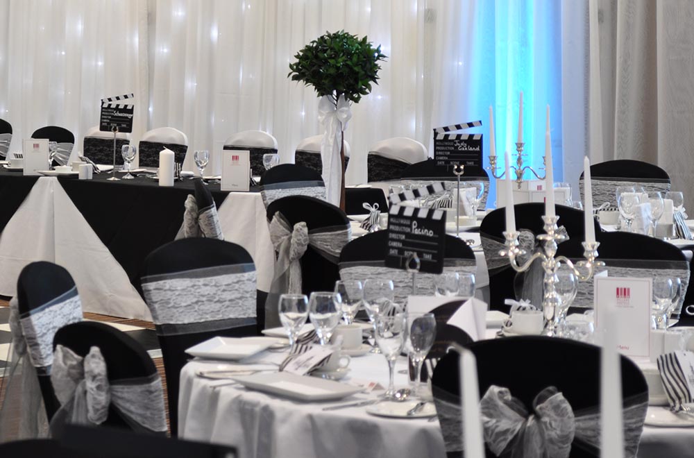 Black and white wedding with contrasting chair covers and lace sashes for a wedding at De Vere Cotswold waterpark hotel