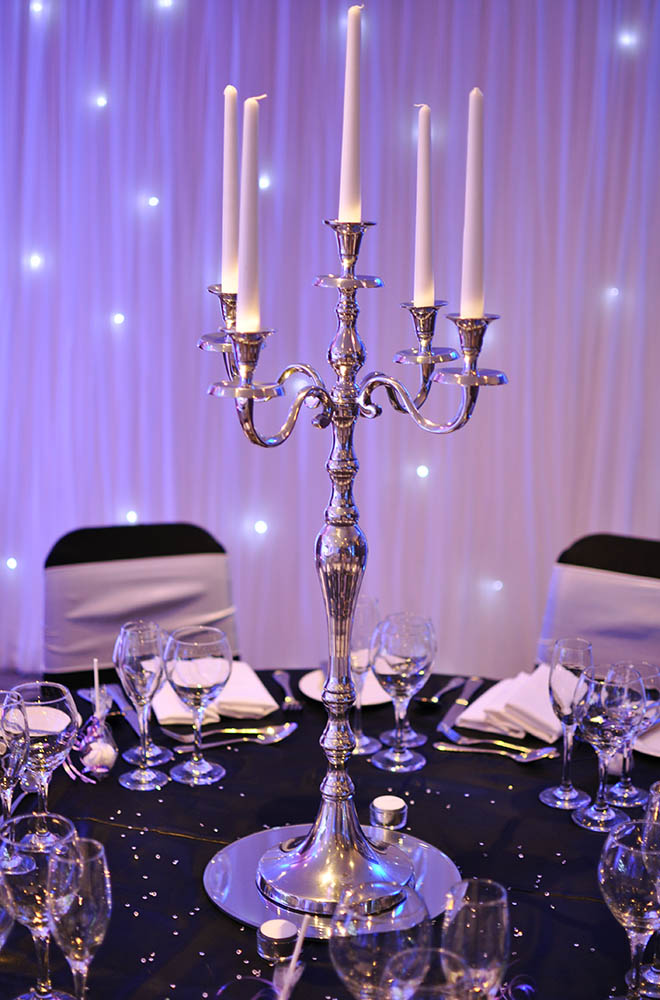 Silver candelabra wedding centrepiece with candles and starlit backdrop