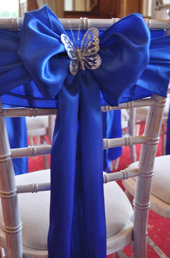 Blue satin chair sash tied with diamond butterfly brooch embellishment