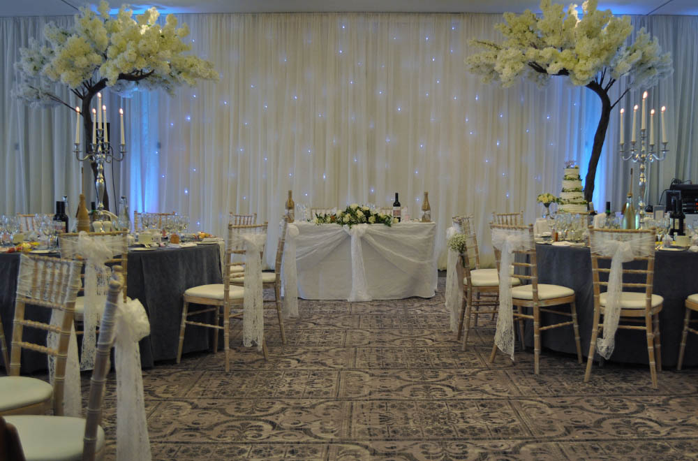Wedding at De Vere Tortworth Court with Drapes and starlit backdrop with Large Blossom Trees