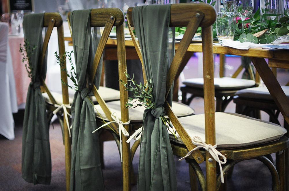 Green Chiffon chair drops with floran foliage tied in bow at the Steam Museum Swindon