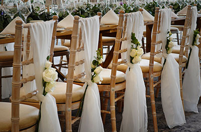 Wooden chairs with chiffon drops at Cotesold Water Park De Vere Hotel