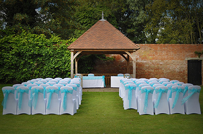 Outdoor ceremony in turquoise at Hatherley Manor