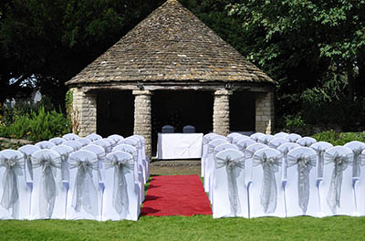 Outdoor wedding, with silver chair sashes, at Stonehouse Court Hotel