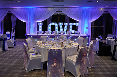 Intimate wedding setup, including window drapes and LOVE letters, at the Village Urban Resort, Swindon