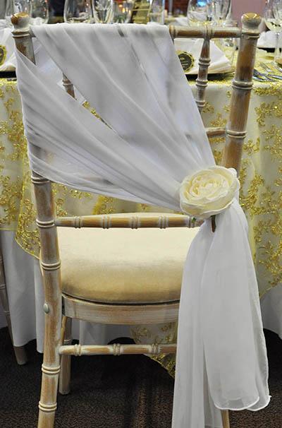 White chiffon chair drops, with extra floral detailing, on chiviari chairs