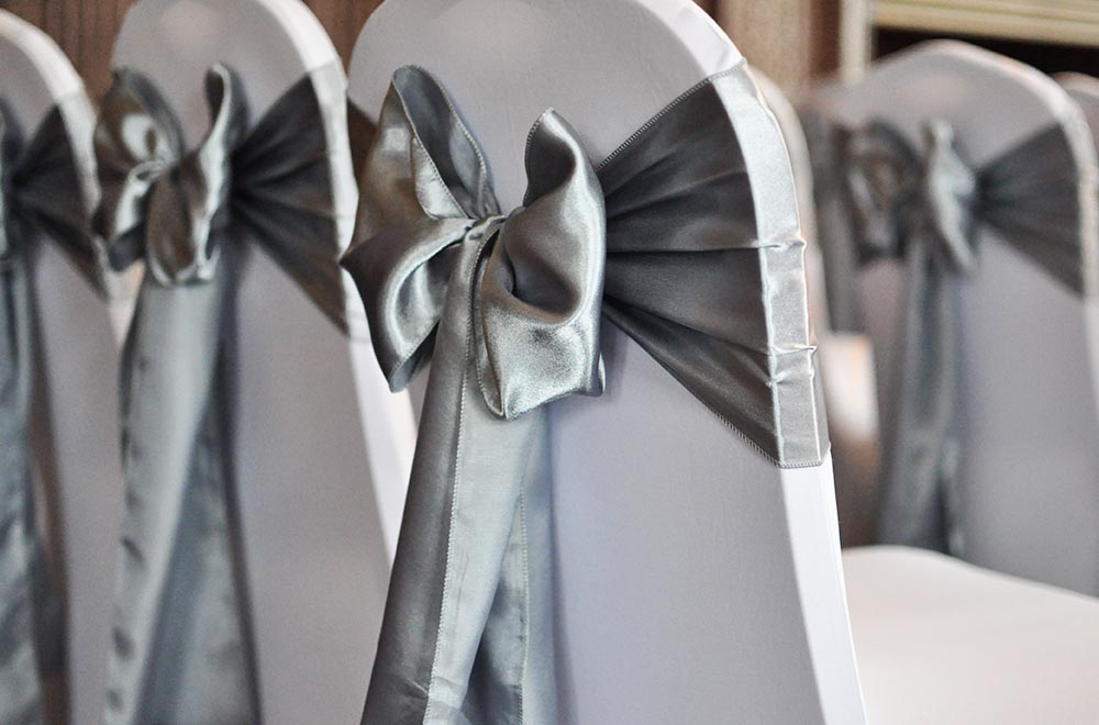 Silver Satin Chair Sash Bows on white chair covers at Dunbleton Hall Hotel