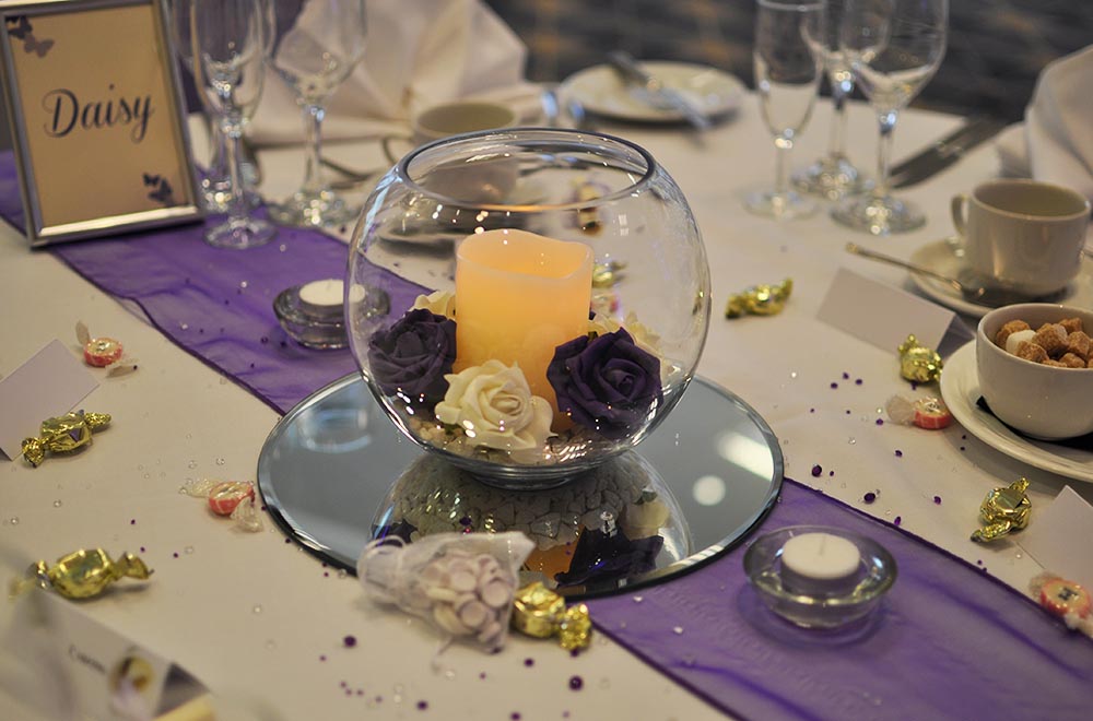 Purple wedding fishbowl centre with Candles and artificial flowers head