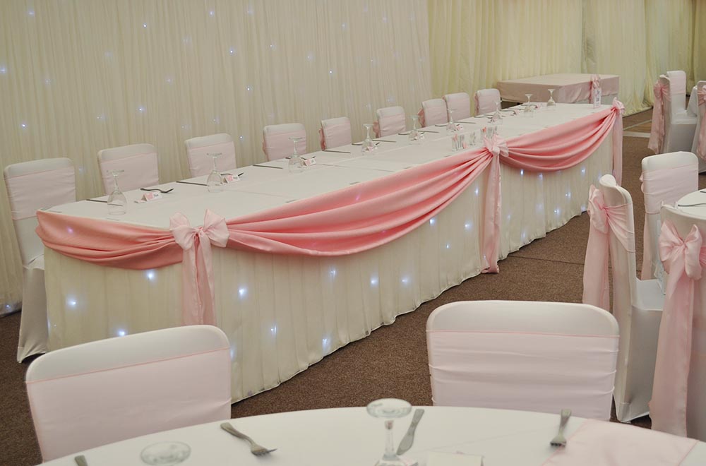 Wedding at Spittleborough farmhouse with LED starlit top table skirt and Pink Swag