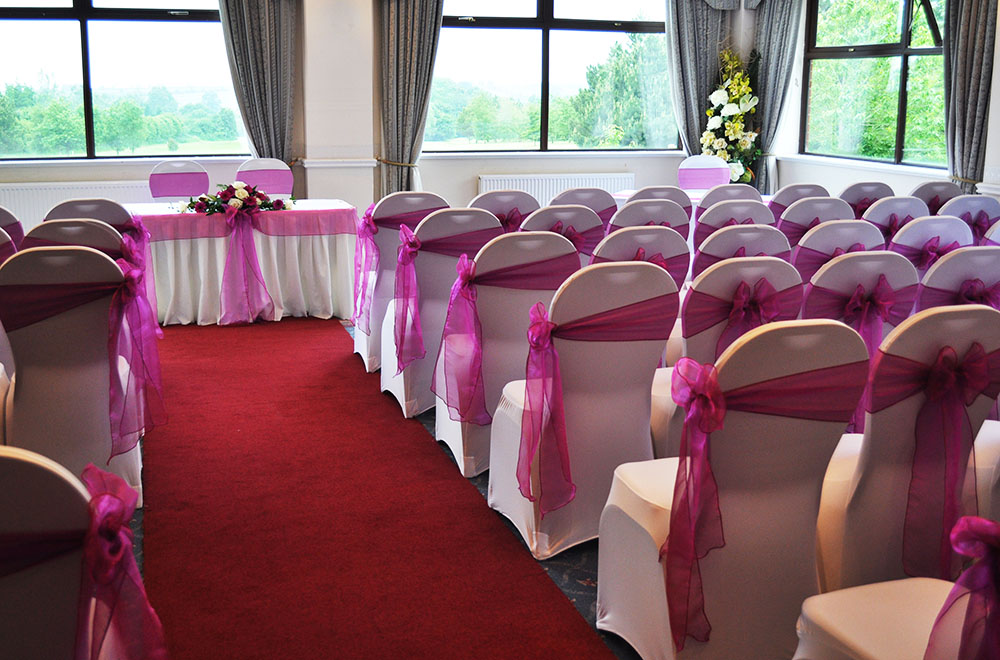 Pink Chair sashes and chair covers at a wedding ceremony at Wrag barn Golf Club